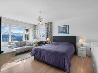This stunning bedroom boasts breathtaking mountain views from its large windows, creating a serene and relaxing atmosphere.