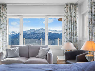 Luxury mountain view room with a comfortable couch and stylish lamps.