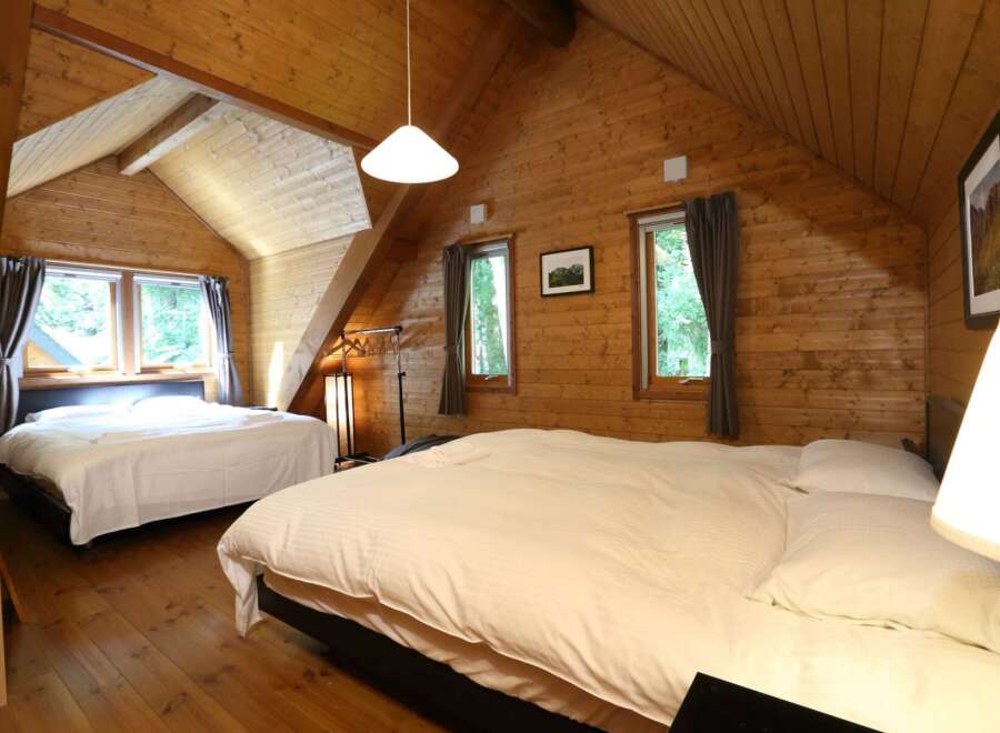 Cozy cabin with two bedrooms, each featuring a comfortable double bed and crisp white linens.