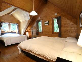 Cozy cabin with two bedrooms, each featuring a comfortable double bed and crisp white linens.