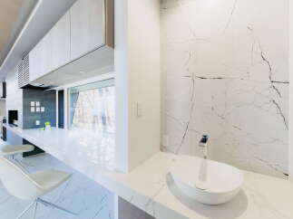This stunning modern kitchen boasts sleek cabinetry, a built-in grill, and expansive window views.