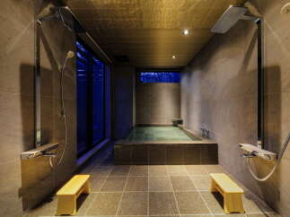 Indulge in tranquility at our luxurious hotel, featuring a private onsen bath with sleek shower facilities.