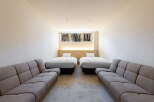 Relax in this serene hotel room featuring two comfy twin beds and two plush sofas, perfect for a family getaway.