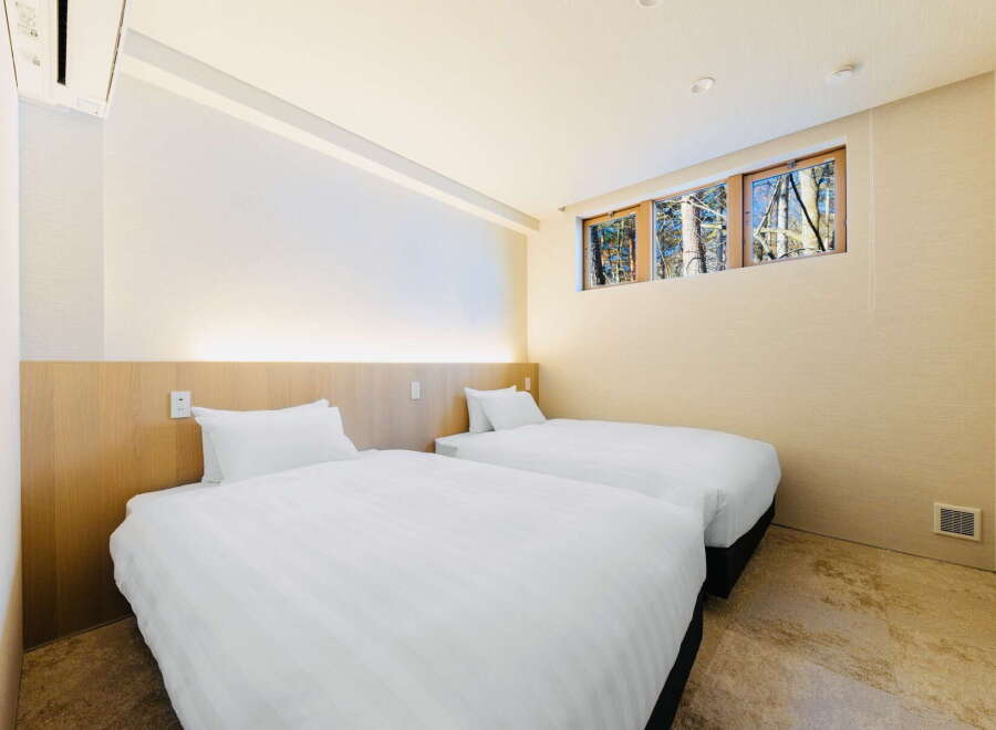 Wake up to stunning forest views from this cozy twin bedroom.