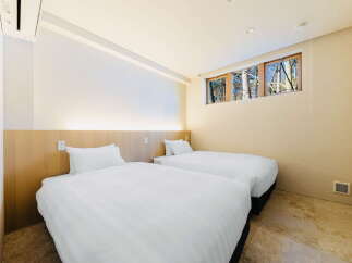 Wake up to stunning forest views from this cozy twin bedroom.