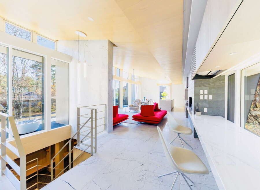 Stunning modern home with open floor plan, showcasing a sleek marble floor and large windows offering abundant natural light.