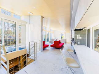 Stunning modern home with open floor plan, showcasing a sleek marble floor and large windows offering abundant natural light.