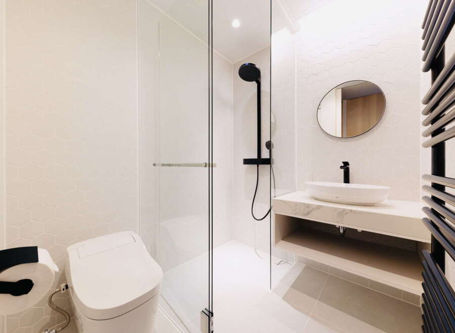 Modern bathroom with hexagonal tiles, walk-in shower, and floating vanity.
