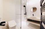 Modern bathroom with hexagonal tiles, walk-in shower, and floating vanity.
