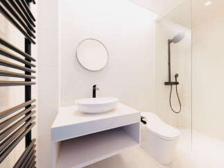 Modern bathroom with white hexagonal tiles, a sleek floating vanity, and a frameless glass shower enclosure.