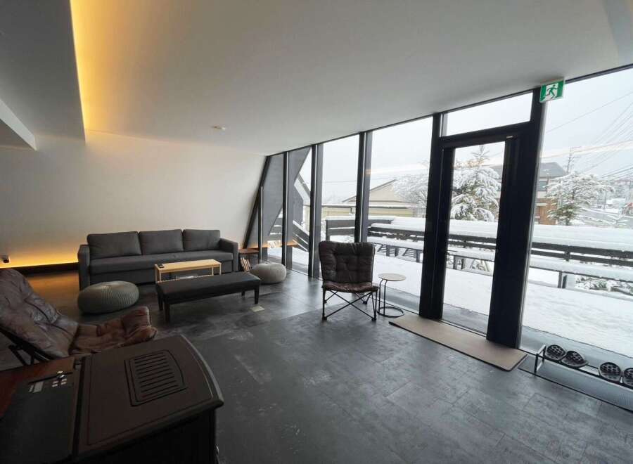 Cozy up by the fireplace in this modern living space, complete with comfortable seating and stunning views of a snow-covered landscape.