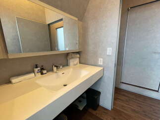 Modern bathroom with sleek white sink and vanity, large mirror, and stylish fixtures.