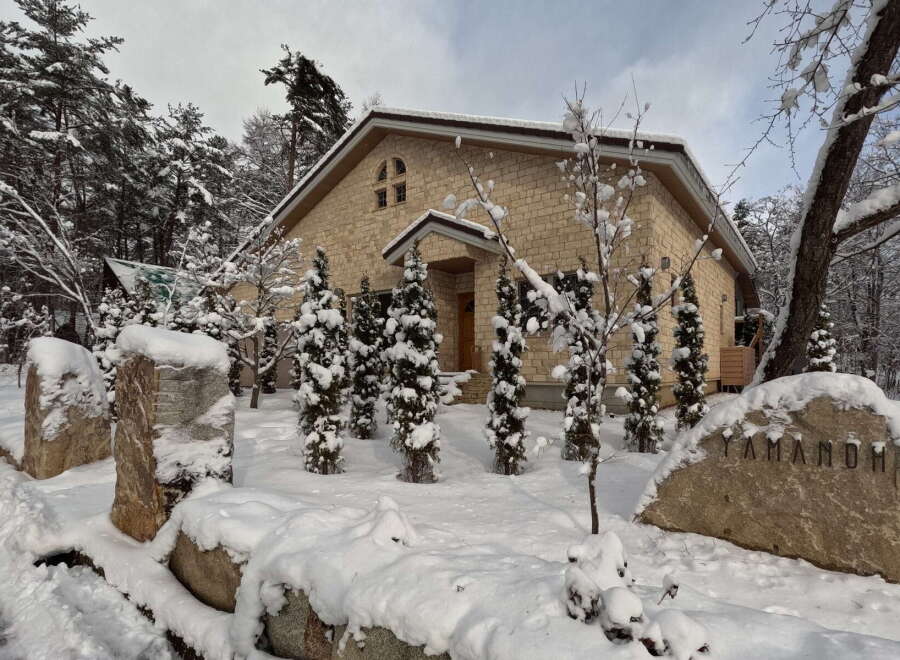 This stunning property boasts a unique stone exterior, perfectly complementing its snowy surroundings.