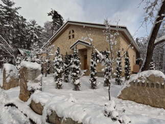 This stunning property boasts a unique stone exterior, perfectly complementing its snowy surroundings.