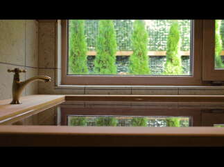 Relax in this luxurious bathroom featuring a wooden bathtub and a vintage-style faucet.