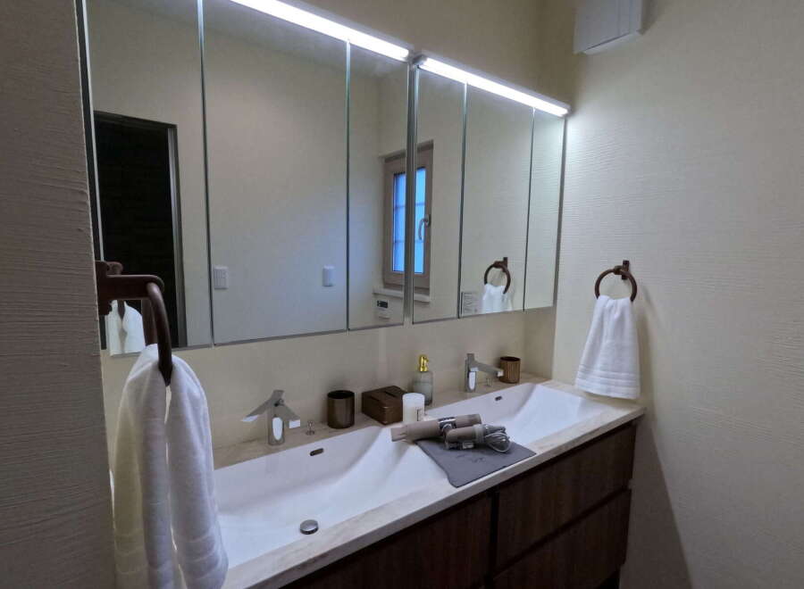 This stunning bathroom boasts a double vanity with sleek, modern sinks and ample counter space.