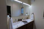 This stunning bathroom boasts a double vanity with sleek, modern sinks and ample counter space.