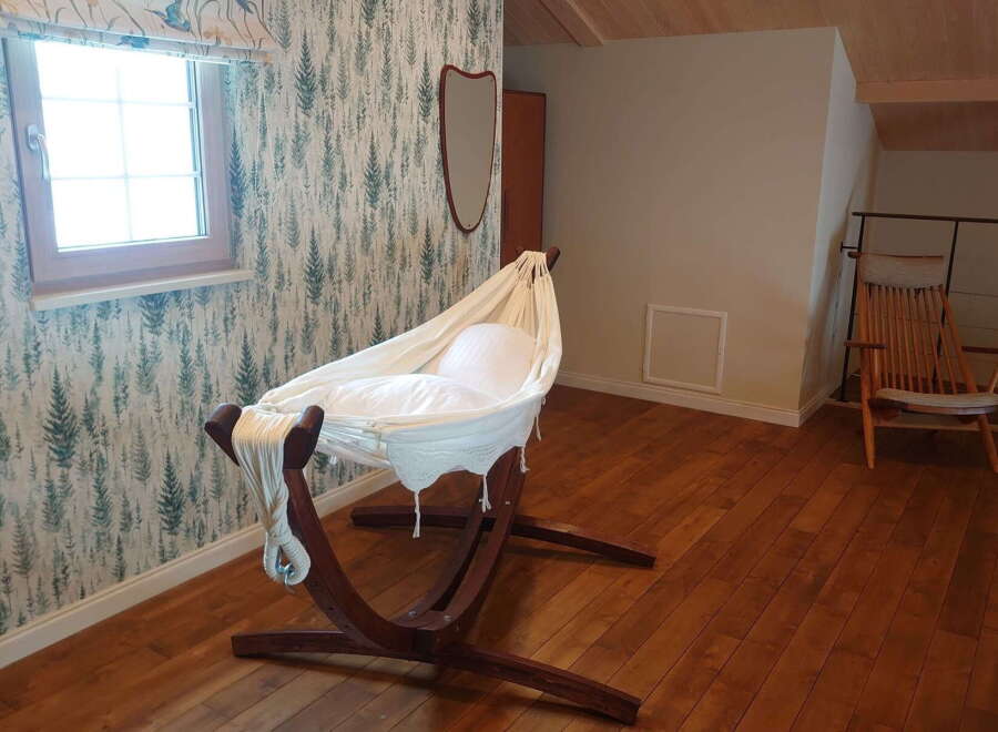 Cozy nursery with a unique hammock crib, perfect for a peaceful sleep.