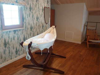 Cozy nursery with a unique hammock crib, perfect for a peaceful sleep.