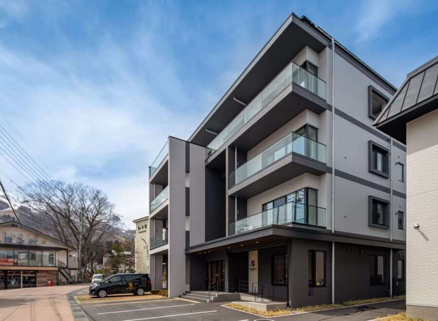 This stunning modern building boasts spacious balconies with glass railings, offering breathtaking views.
