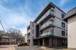 This stunning modern building boasts spacious balconies with glass railings, offering breathtaking views.