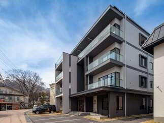 This stunning modern building boasts spacious balconies with glass railings, offering breathtaking views.