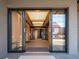 Modern building with sleek glass and metal entrance.