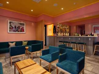 Stylish lounge area with teal armchairs and a comfortable sofa, perfect for relaxing after a day of skiing.