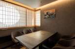 This exquisite dining room boasts a serene ambiance, highlighted by traditional shoji screens and a stunning Great Wave print.