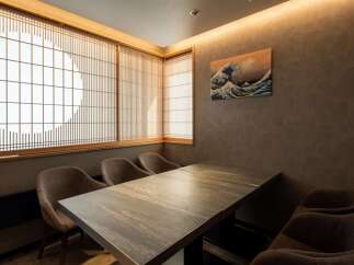 This exquisite dining room boasts a serene ambiance, highlighted by traditional shoji screens and a stunning Great Wave print.