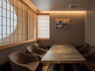 This exquisite dining room boasts a serene ambiance, highlighted by stunning shoji screens and a captivating Great Wave artwork.