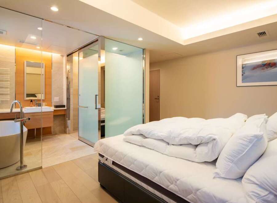 Luxurious bedroom with ensuite bathroom featuring a freestanding bathtub and glass shower enclosure.