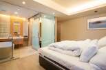 Luxurious bedroom with ensuite bathroom featuring a freestanding bathtub and glass shower enclosure.