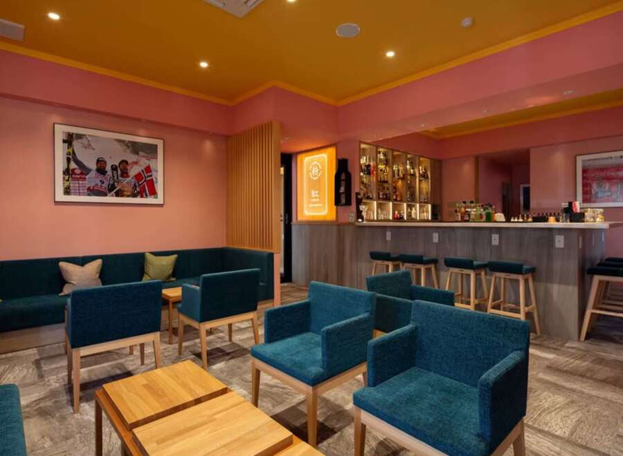 Stylish lounge area with teal armchairs and a comfortable sofa, perfect for relaxing after a day of skiing.