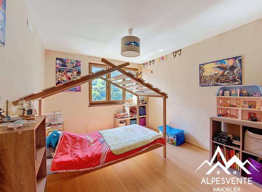 Charming child's bedroom with a wooden bed frame and built-in shelving.