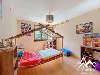 Charming child's bedroom with a wooden bed frame and built-in shelving.