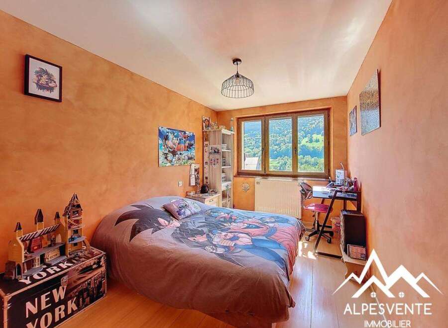 Charming bedroom with mountain views, featuring a comfortable bed and a dedicated workspace.