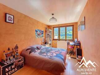 Charming bedroom with mountain views, featuring a comfortable bed and a dedicated workspace.