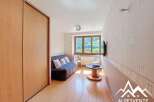 Cozy room with built-in wooden wardrobe and a comfortable sofa, perfect for relaxation.