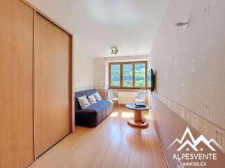 Cozy room with built-in wooden wardrobe and a comfortable sofa, perfect for relaxation.