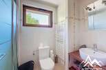This stunning bathroom boasts modern fixtures and finishes, including a sleek white toilet and a spacious vanity with a vessel sink.