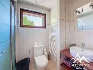 This stunning bathroom boasts modern fixtures and finishes, including a sleek white toilet and a spacious vanity with a vessel sink.