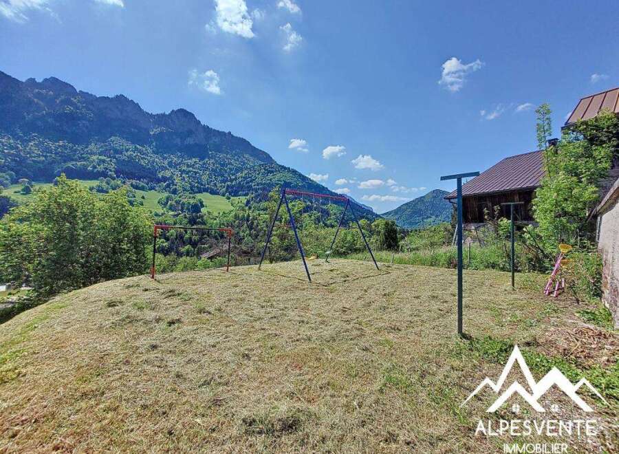 Mountain view property with a spacious yard perfect for kids, featuring a swing set and ample room for outdoor activities.