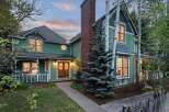 Charming Victorian home nestled in a serene landscape, featuring a spacious front porch and meticulously maintained gardens.