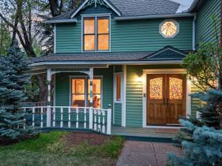 Charming Victorian home with a wrap-around porch and beautiful stained-glass details.
