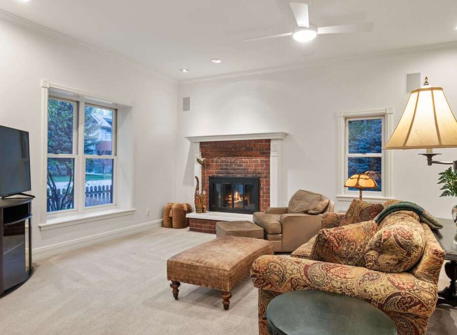 Cozy family room features a brick fireplace, creating a warm and inviting atmosphere.