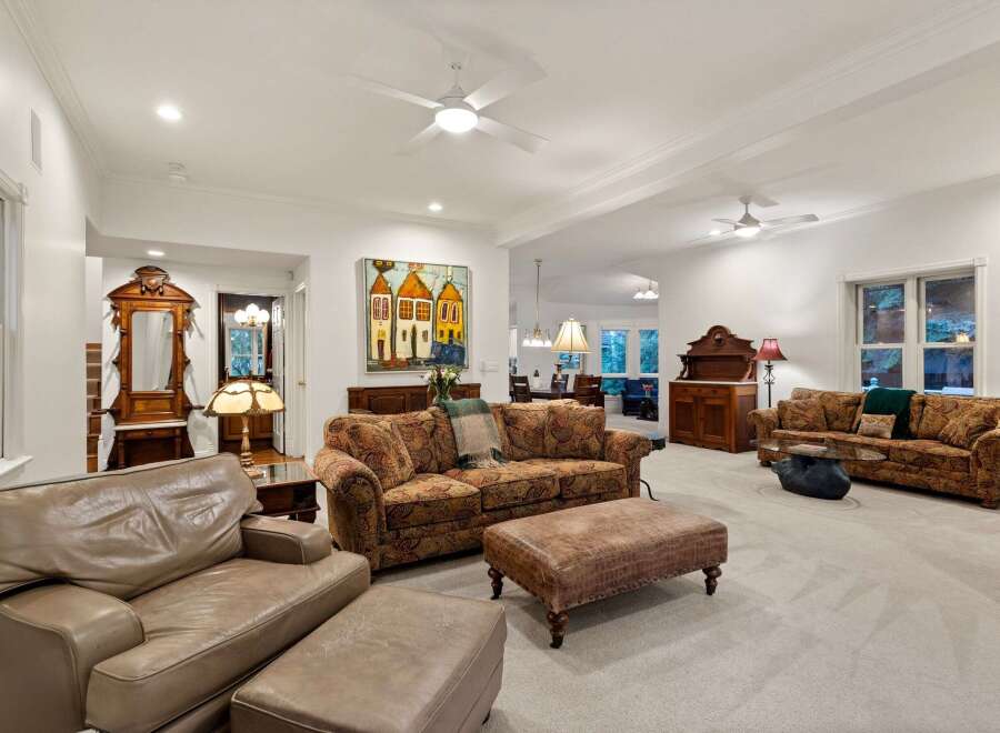 This stunning living room boasts high ceilings, crown molding, and hardwood floors, creating an elegant and spacious atmosphere.