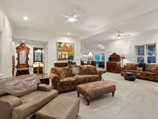 This stunning living room boasts high ceilings, crown molding, and hardwood floors, creating an elegant and spacious atmosphere.
