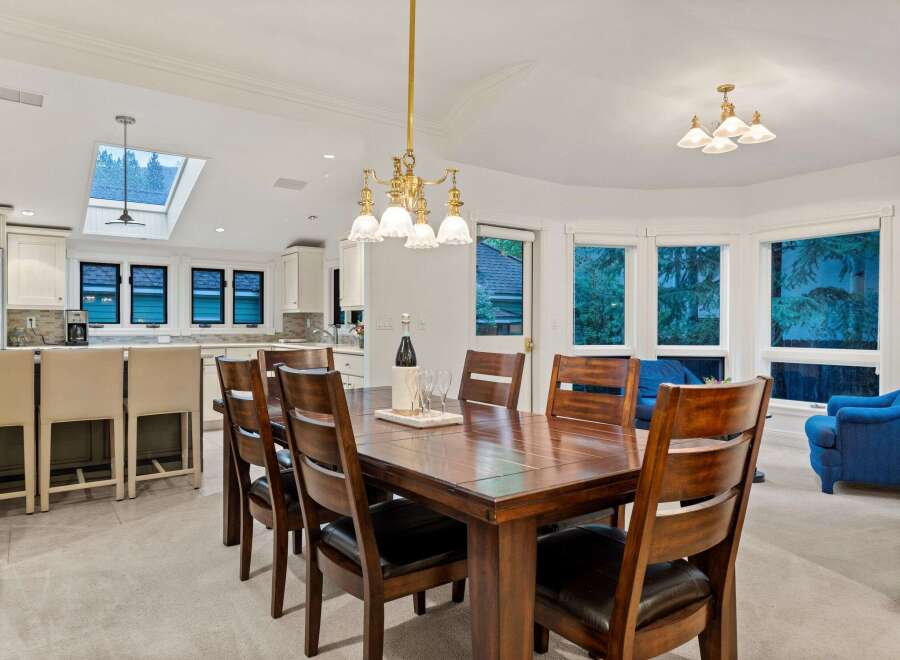 This stunning dining room boasts a large wooden table surrounded by comfortable leather chairs, perfect for family gatherings.