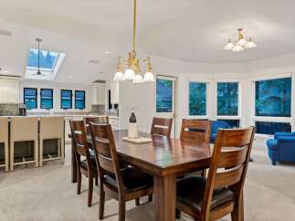 This stunning dining room boasts a large wooden table surrounded by comfortable leather chairs, perfect for family gatherings.